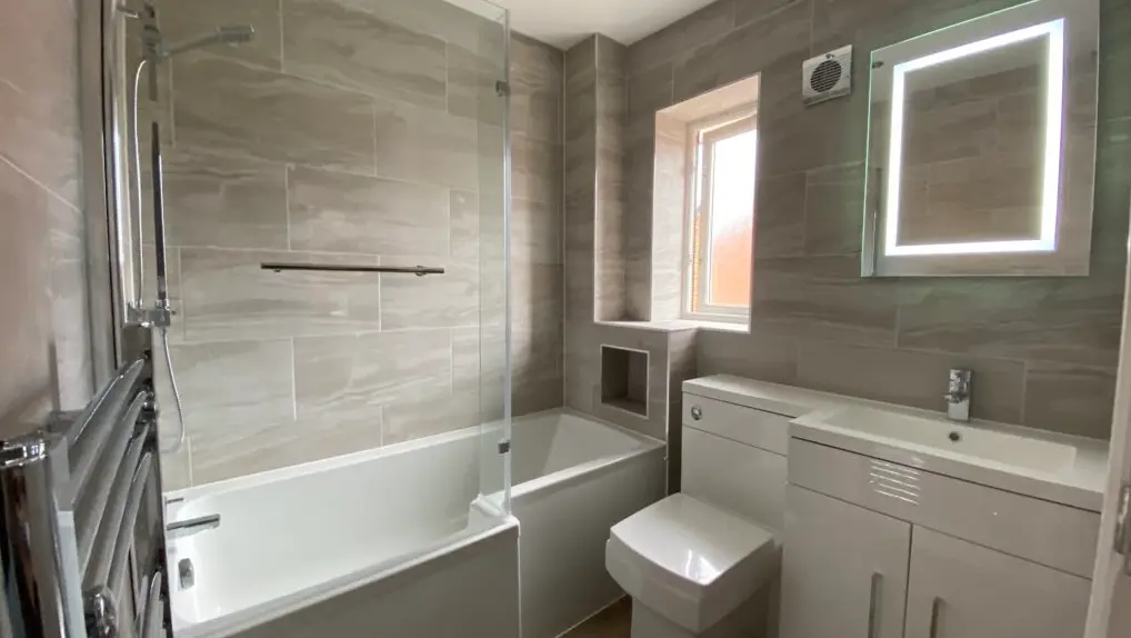 Bathroom renovation in Cardiff with stone-effect wall finishes and vanity storage